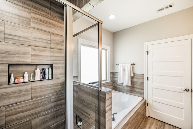 bathroom featuring a shower stall, visible vents, and a bath