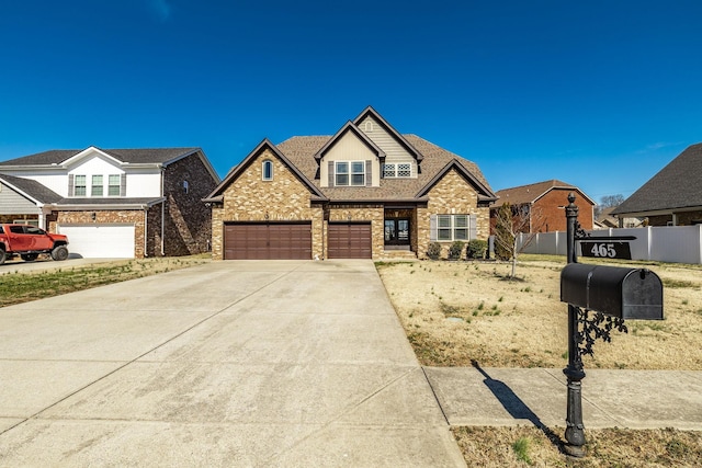 view of front facade with a garage, driveway, a shingled roof, and fence