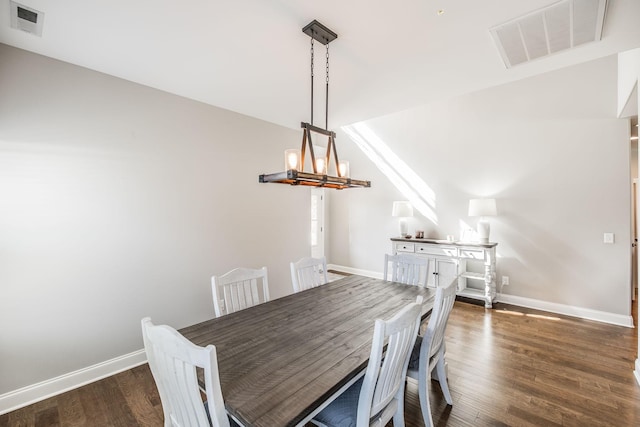 dining room featuring a notable chandelier, dark wood-type flooring, visible vents, and baseboards