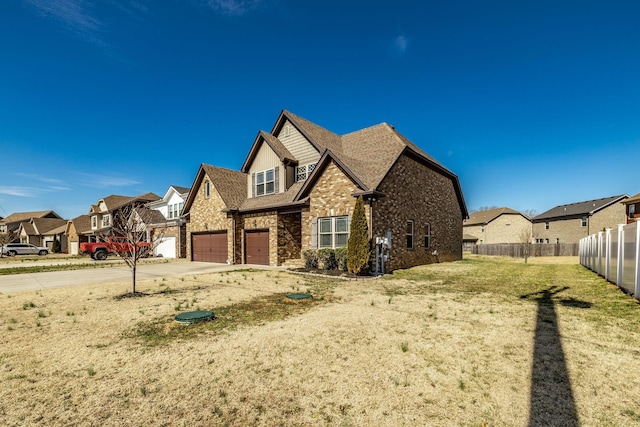 view of front of home with brick siding, concrete driveway, fence, a garage, and a residential view