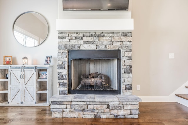 details with a fireplace, baseboards, and wood finished floors