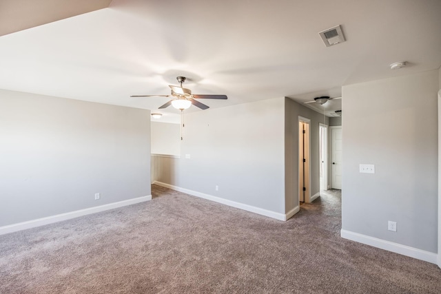 carpeted empty room with visible vents, ceiling fan, and baseboards