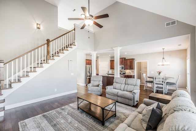 living area featuring dark wood-style flooring, decorative columns, visible vents, stairway, and baseboards