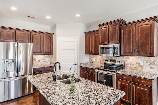 kitchen with dark brown cabinetry, visible vents, stainless steel appliances, and a sink