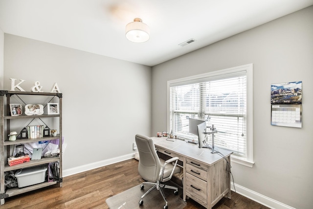 office space featuring baseboards, visible vents, and dark wood-type flooring