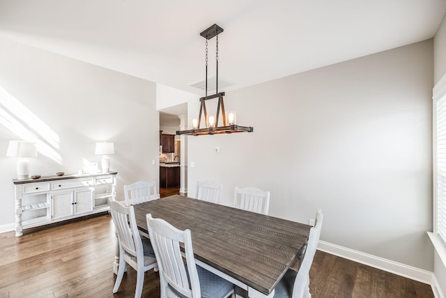 dining area with a notable chandelier, baseboards, and wood finished floors