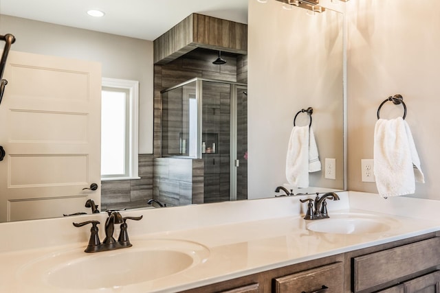 bathroom featuring double vanity, a sink, and a shower stall