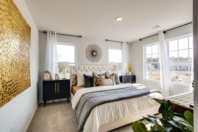 carpeted bedroom featuring multiple windows, visible vents, and baseboards