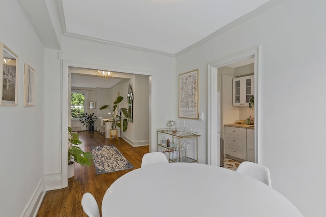 dining space with baseboards, wood finished floors, and crown molding