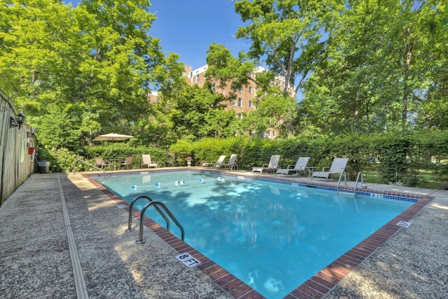 pool featuring fence and a patio