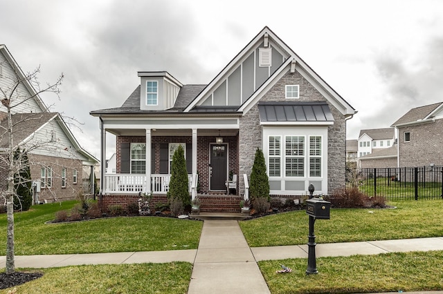 craftsman house featuring a standing seam roof, fence, a front lawn, and a porch