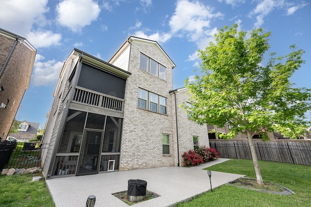 back of property featuring fence, a sunroom, brick siding, and a patio