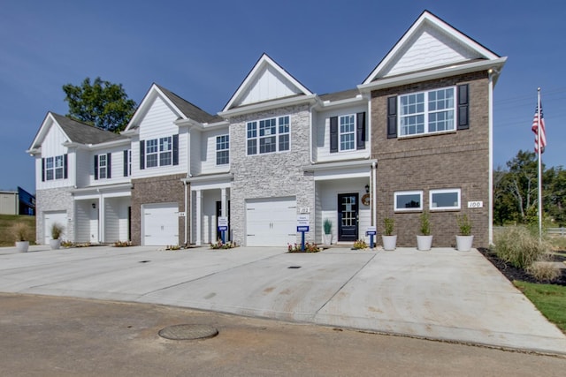 view of front of property with driveway, brick siding, board and batten siding, and an attached garage