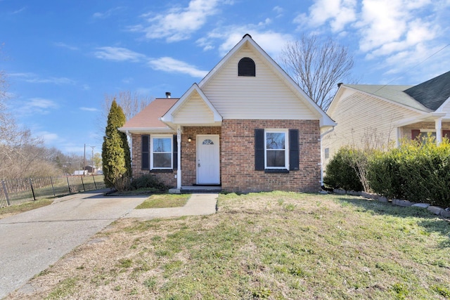 bungalow-style home featuring brick siding, fence, and a front lawn