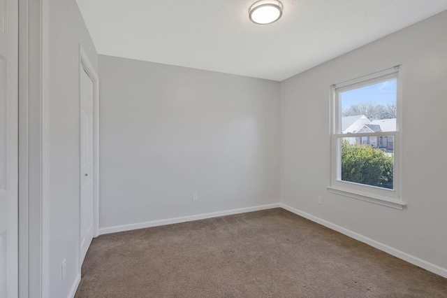 unfurnished room with carpet floors and baseboards