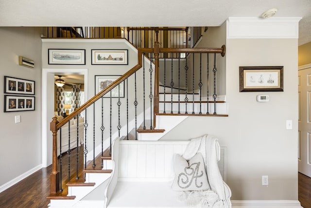 staircase with baseboards, a ceiling fan, and wood finished floors