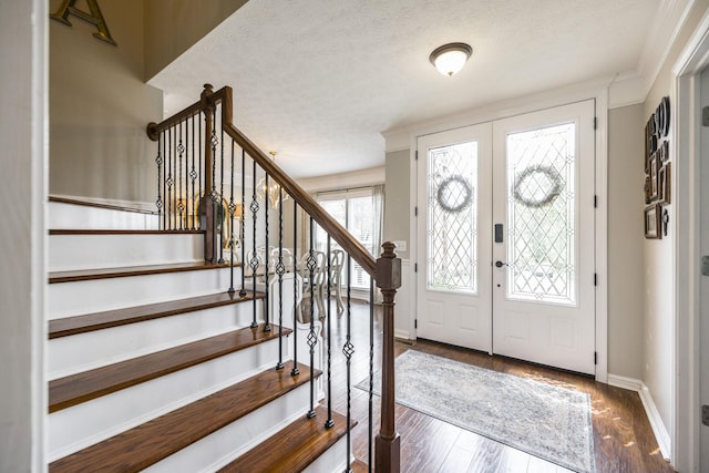 foyer featuring baseboards, stairway, wood finished floors, a textured ceiling, and french doors