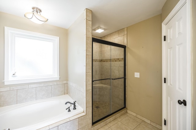 full bathroom with a shower stall, a bath, and tile patterned floors