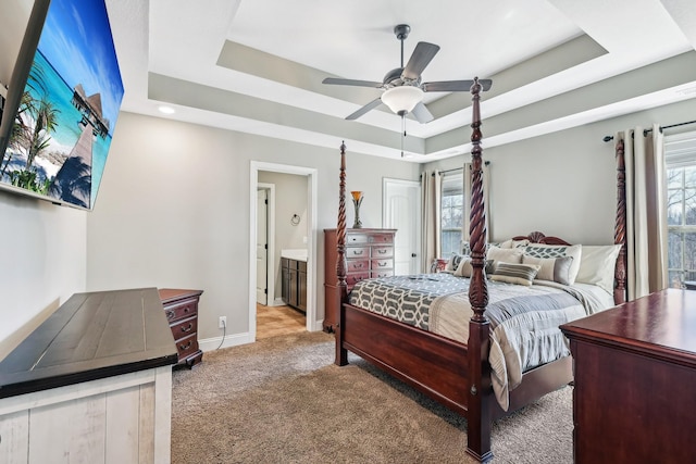 bedroom featuring multiple windows, baseboards, a raised ceiling, and carpet flooring