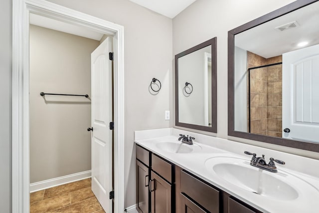 bathroom with double vanity, baseboards, visible vents, and a sink