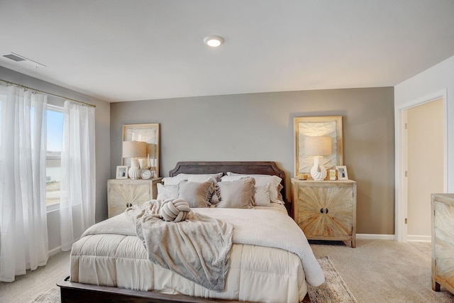 bedroom featuring baseboards, visible vents, and light colored carpet