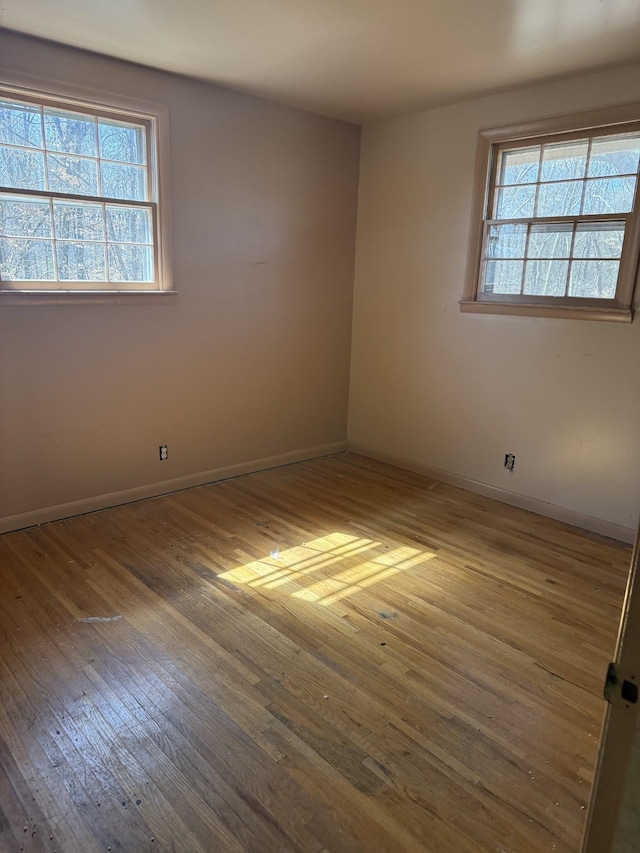 unfurnished room featuring baseboards and hardwood / wood-style floors