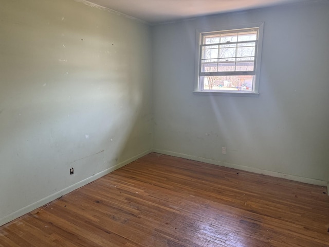 empty room with baseboards and wood finished floors