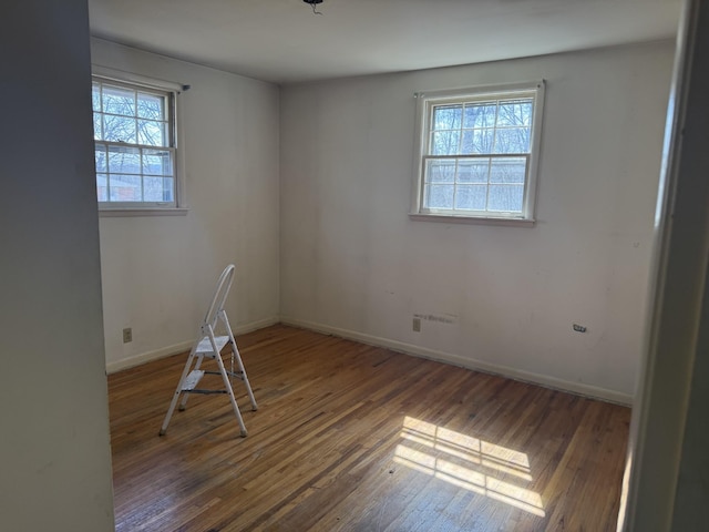 spare room featuring wood finished floors and baseboards