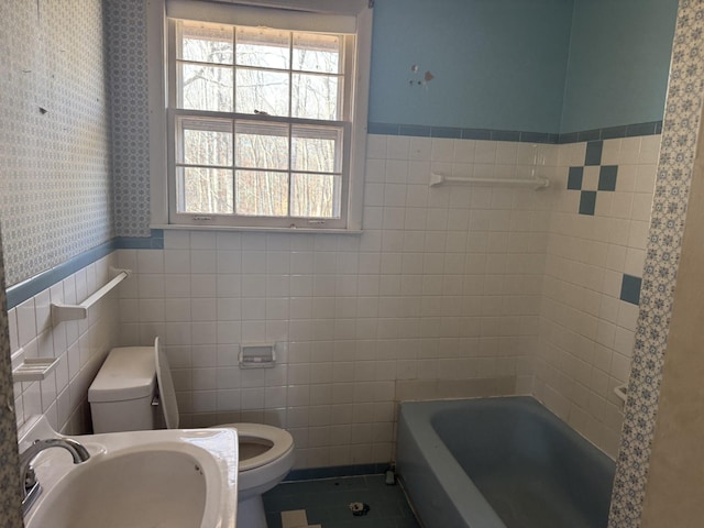 full bath featuring a wainscoted wall, a sink, toilet, and a healthy amount of sunlight