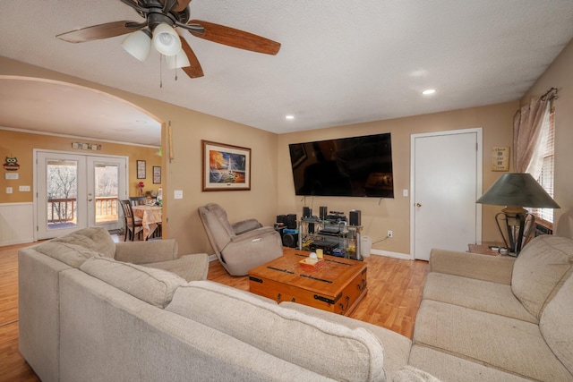 living room with arched walkways, french doors, recessed lighting, and wood finished floors