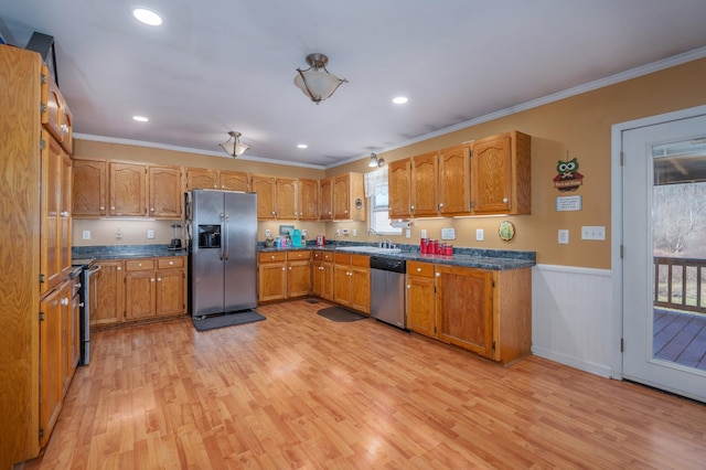 kitchen featuring appliances with stainless steel finishes, light wood-style flooring, and crown molding