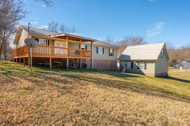 back of property with metal roof, a lawn, and a wooden deck