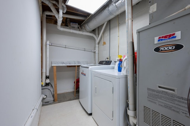 washroom with laundry area, washing machine and dryer, and heating unit