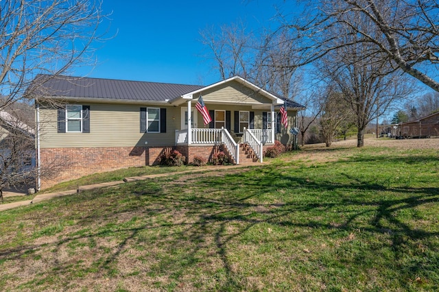 ranch-style home with covered porch, metal roof, and a front yard