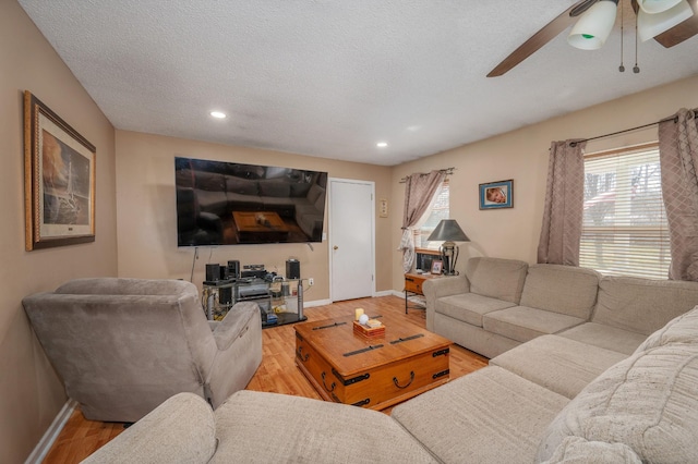 living area featuring baseboards, a ceiling fan, wood finished floors, a textured ceiling, and recessed lighting