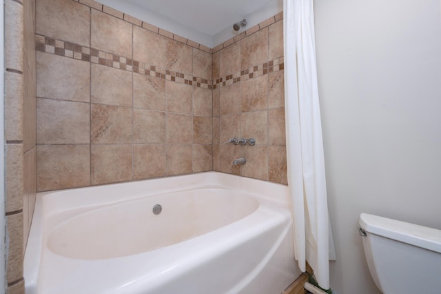 bathroom with shower / bath combination with curtain and toilet