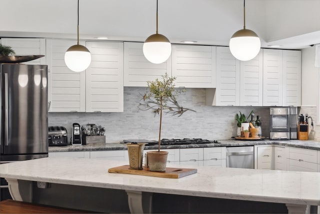 kitchen featuring freestanding refrigerator, white cabinetry, and decorative backsplash