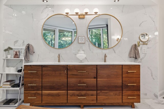 full bath with recessed lighting, marble finish floor, a sink, and double vanity