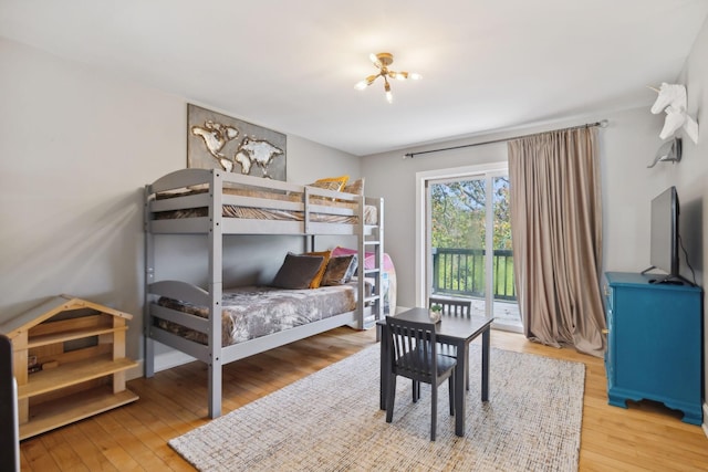 bedroom with access to outside and hardwood / wood-style flooring