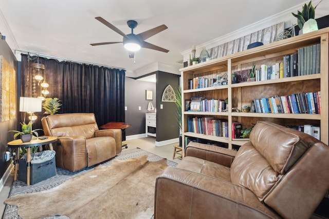 living area featuring crown molding, baseboards, and ceiling fan