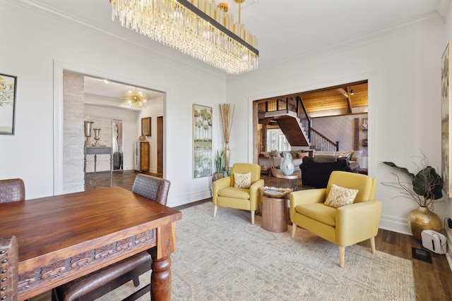 interior space featuring crown molding, stairway, wood finished floors, a chandelier, and baseboards