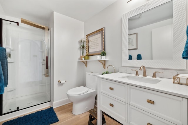 full bathroom with toilet, vanity, a shower stall, wood finished floors, and baseboards