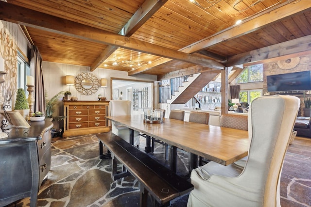 dining space with stone floors, wooden ceiling, beam ceiling, and stairs