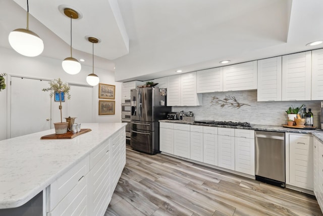 kitchen with light wood finished floors, stainless steel appliances, recessed lighting, tasteful backsplash, and white cabinets