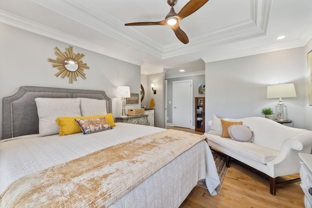 bedroom featuring a ceiling fan, a raised ceiling, wood finished floors, and recessed lighting