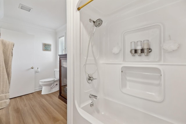 bathroom with toilet, bathing tub / shower combination, crown molding, and wood finished floors