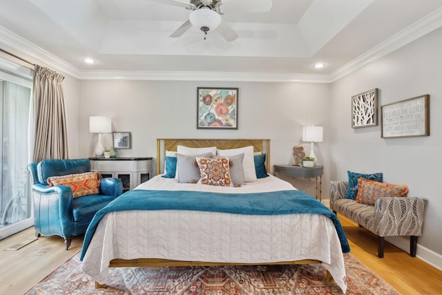 bedroom featuring baseboards, a tray ceiling, and wood finished floors