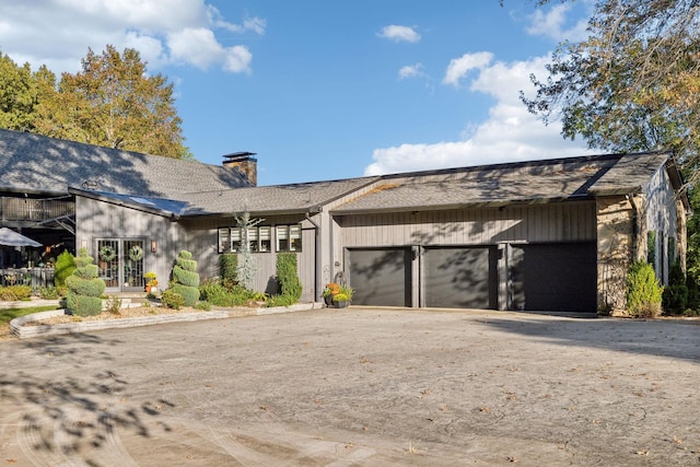 view of front of home featuring an attached garage and a chimney