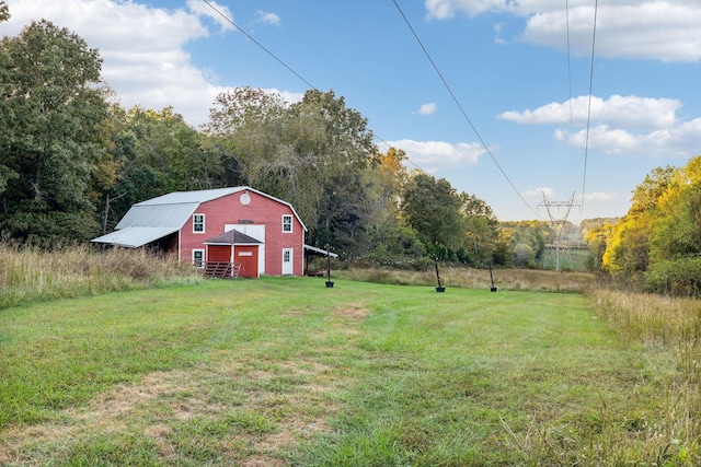 view of yard featuring a garage, driveway, a barn, and an outdoor structure