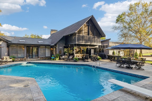 pool with a sunroom, a grill, a patio, and an outdoor living space